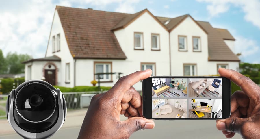Man holding mobile device and checking footage from video cameras